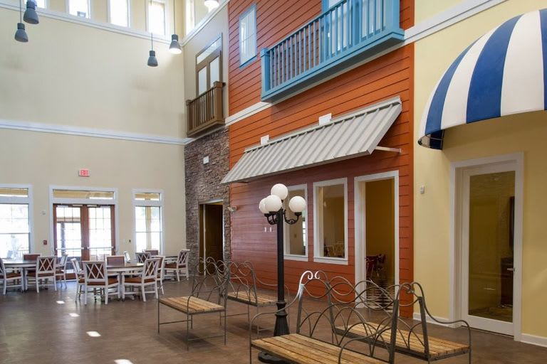 An indoor space designed to resemble an outdoor street scene with colorful facades, balconies, and street lamps.