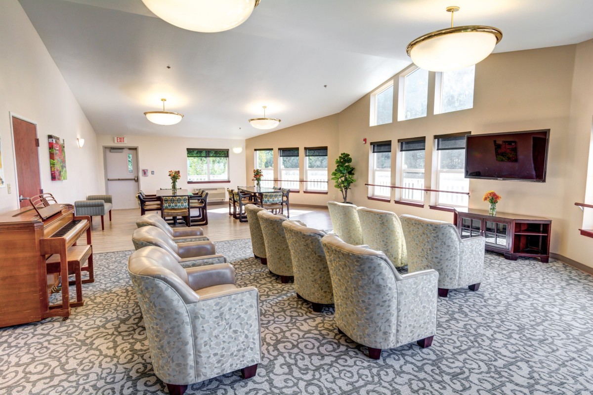 A spacious and well-lit lounge area with comfortable seating and large windows.