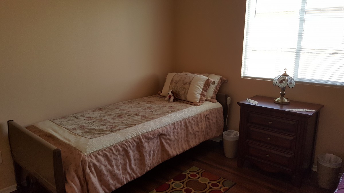 A cozy bedroom with a single bed, dresser, and window.
