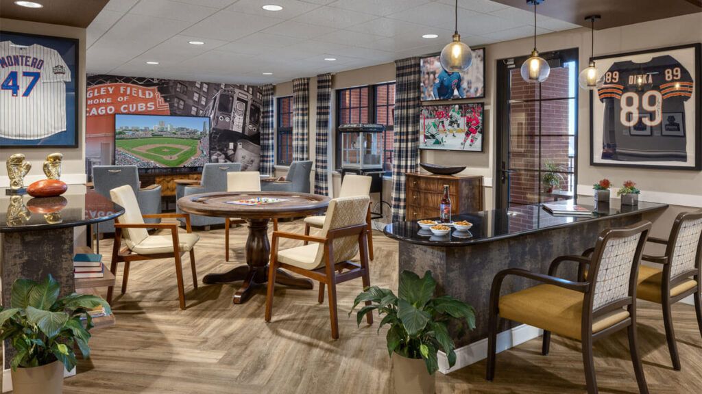 A stylish interior room with a round table, chairs, and decorated walls featuring artwork and pendant lighting.