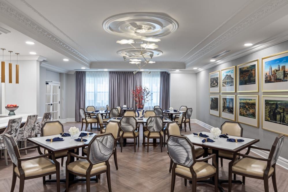 A modern dining room with elegantly set tables and chairs, featuring stylish lighting and decor.