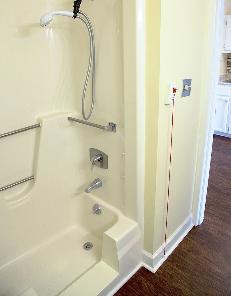Accessible bathroom with grab bars and a shower.