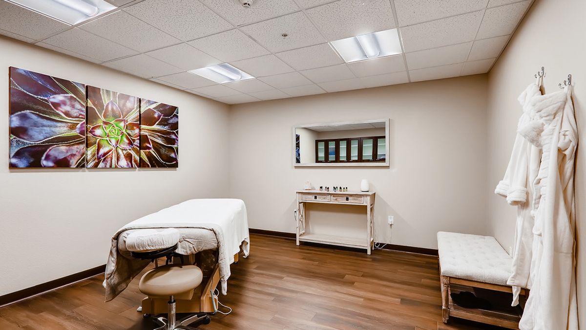 A serene massage therapy room with a treatment table and calming decor.