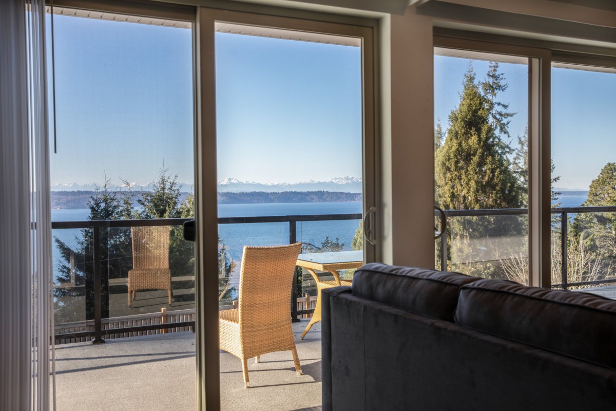 A cozy living room opens up to a balcony with stunning ocean views.