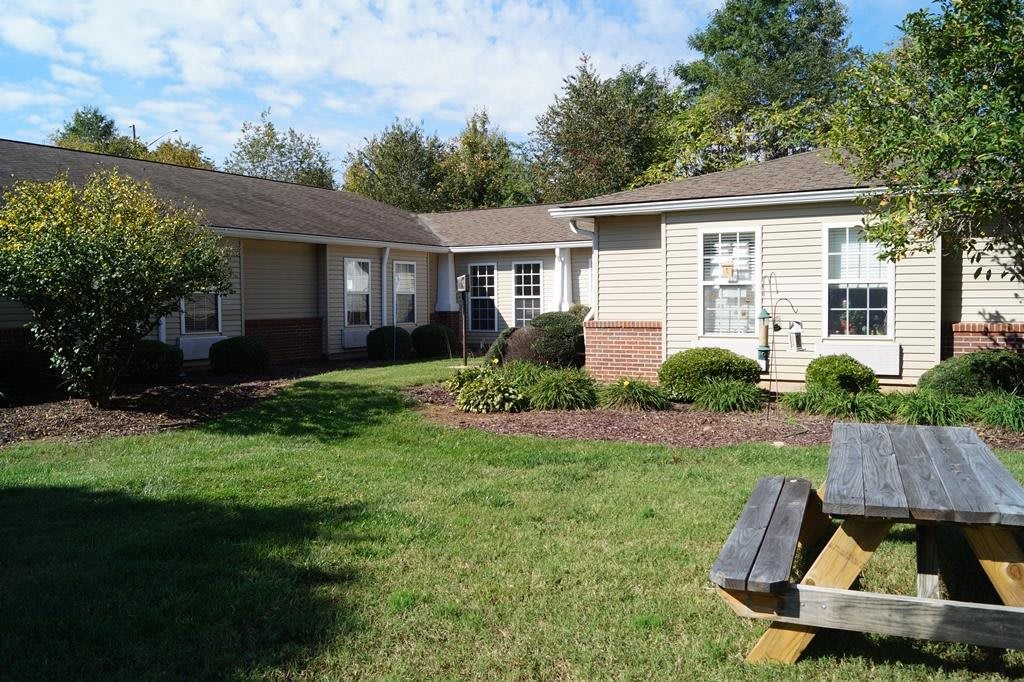 A cozy residential house surrounded by a well-maintained garden and yard.