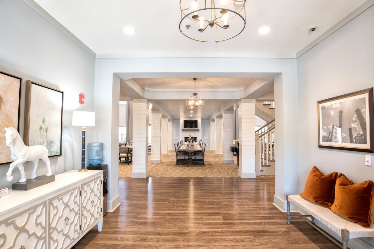 A spacious and modern living area with elegant lighting and wood flooring.