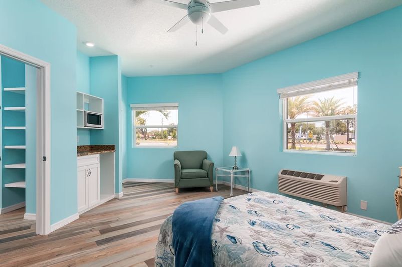 A cozy bedroom with blue walls and modern furnishings.