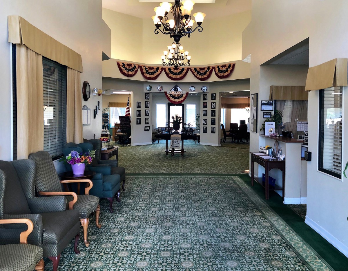 A spacious lobby with comfortable seating, elegant chandeliers, and decorative elements.