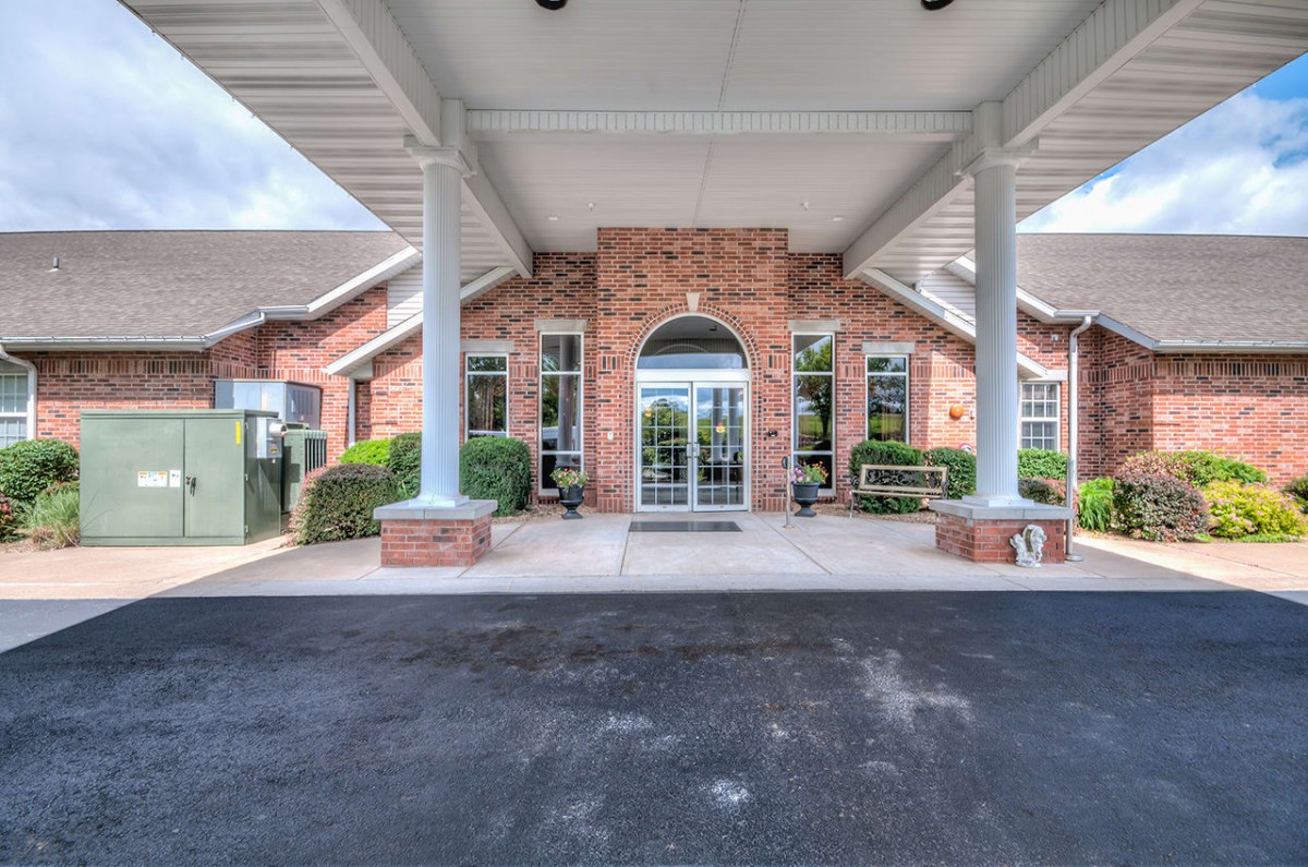 The image shows the entrance of a brick building with a covered walkway.