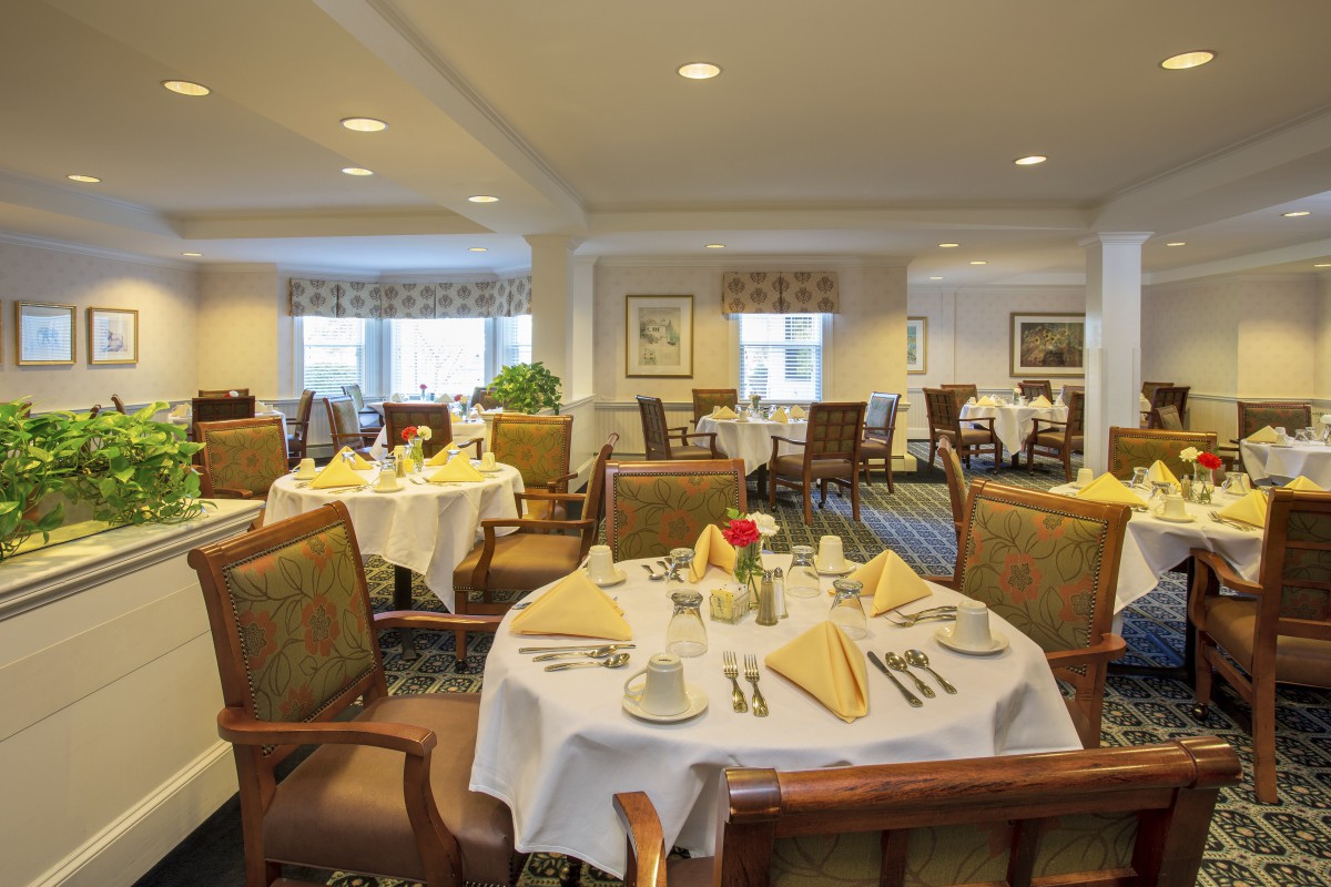 An elegantly set dining room with neatly arranged tables and chairs.