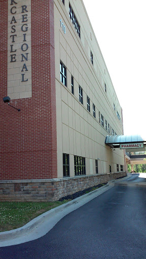 A modern hospital building with a brick faade and connecting walkway.