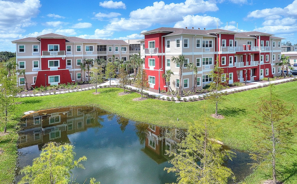 Modern apartment complex with lake view and vibrant architecture.