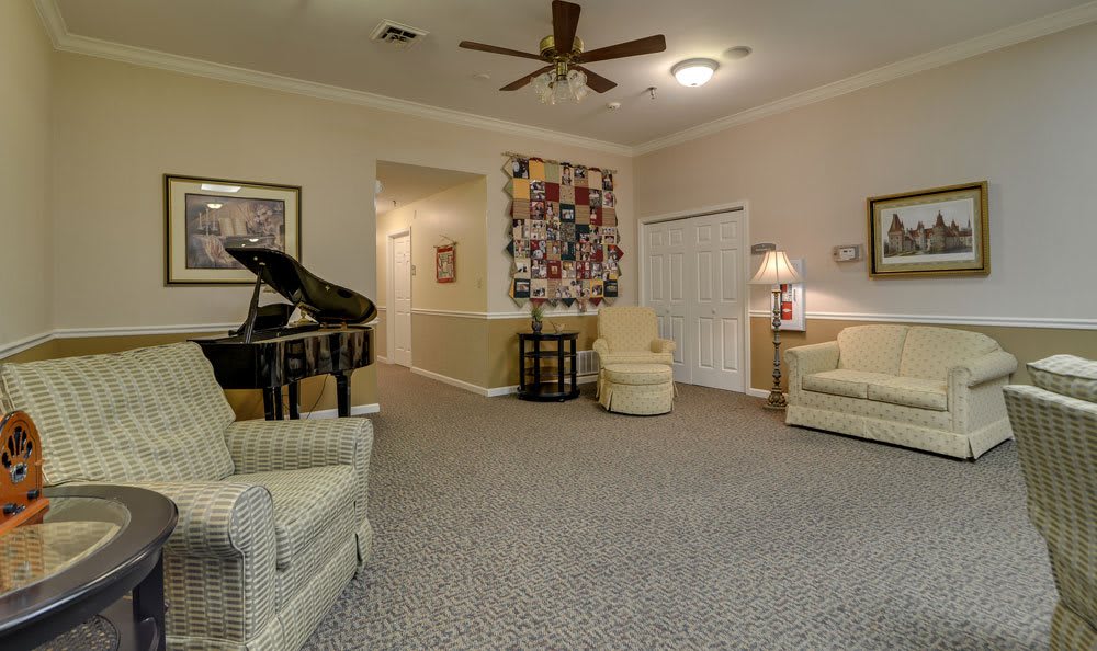 A cozy living room with a piano and comfortable seating.