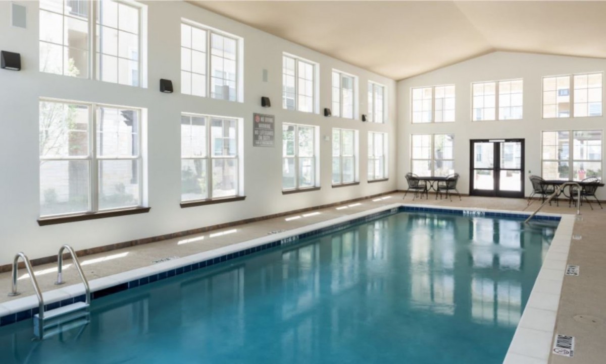 A spacious indoor swimming pool with large windows allowing natural light to fill the room.