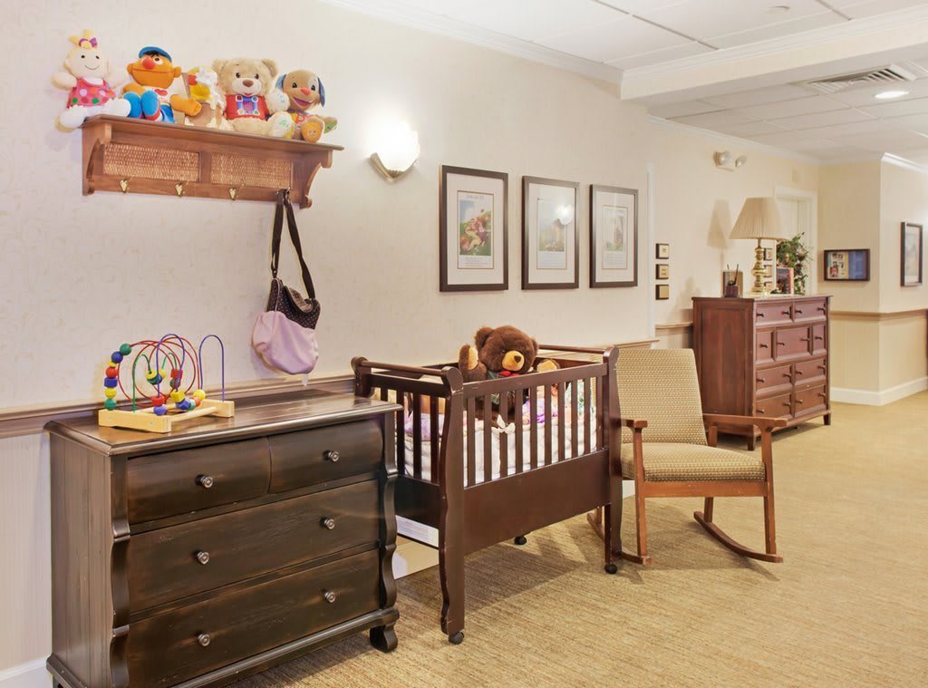 A cozy nursery room with a crib, dresser, and toys.