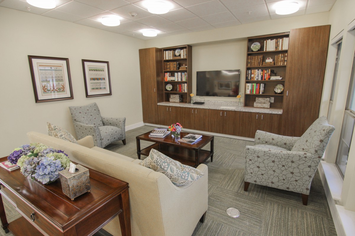 A modern living room featuring comfortable seating, a built-in bookshelf, and a television.