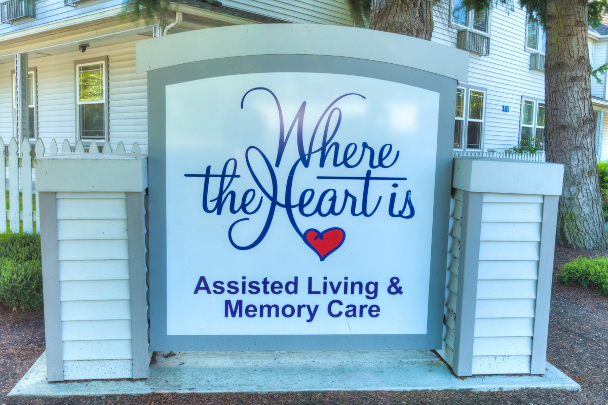 A sign for 'Where the Heart is' Assisted Living & Memory Care facility.