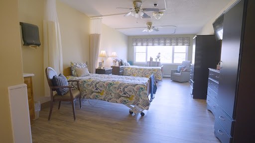 A well-lit, comfortable bedroom featuring two beds, a cozy seating area, and stylish decor.