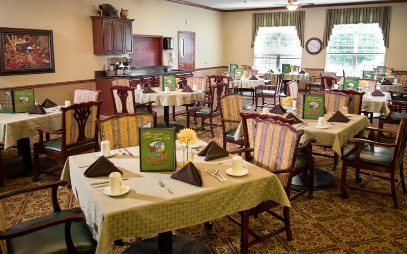 A cozy dining room with neatly set tables and comfortable chairs, ready for guests.