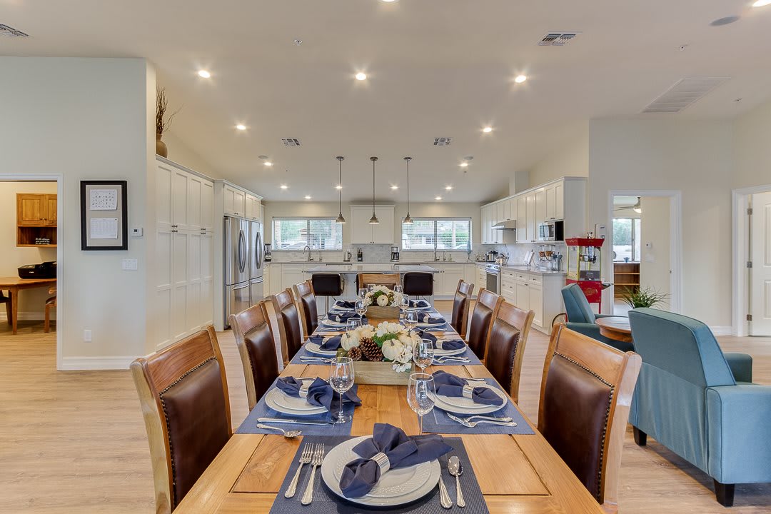 A beautifully set dining table in a modern, open-concept kitchen and dining area.
