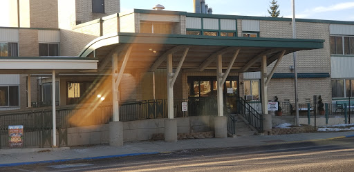 A modern building entrance with a covered walkway and stairs.