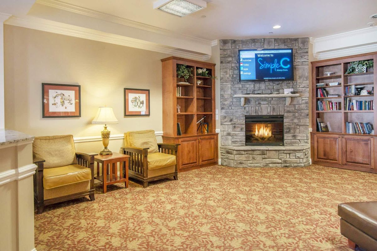 A cozy living room with a stone fireplace, television, and comfortable seating.