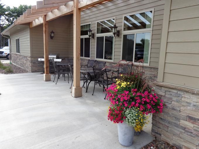 A patio with outdoor seating and a colorful flower planter.