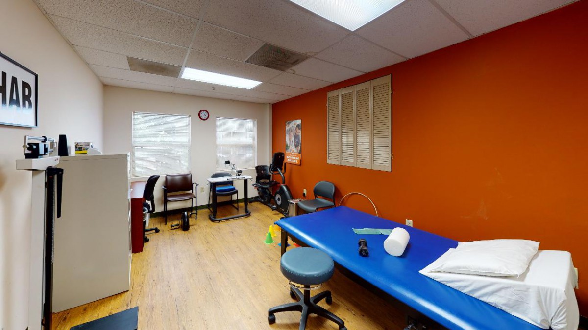 A well-equipped physical therapy room featuring exercise equipment and rehabilitation tools.