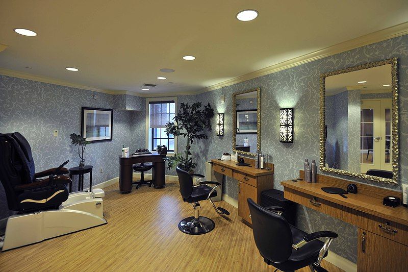 A modern, well-decorated hair salon interior with styling chairs and mirrors.