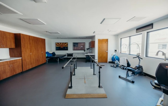 A spacious physical therapy room equipped with various rehabilitation tools and exercise equipment.