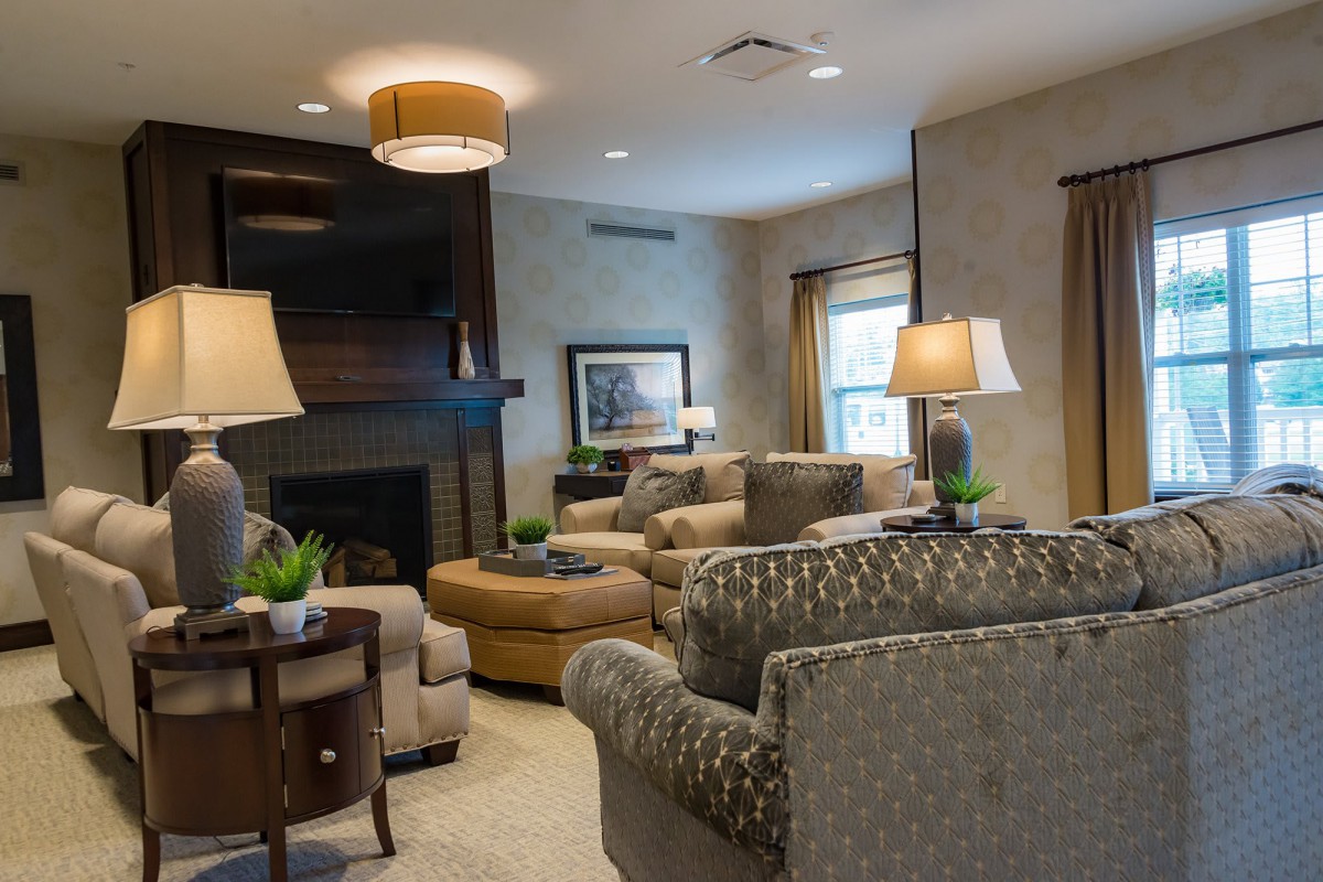A cozy and elegantly furnished living room with comfortable seating and decorative lighting.