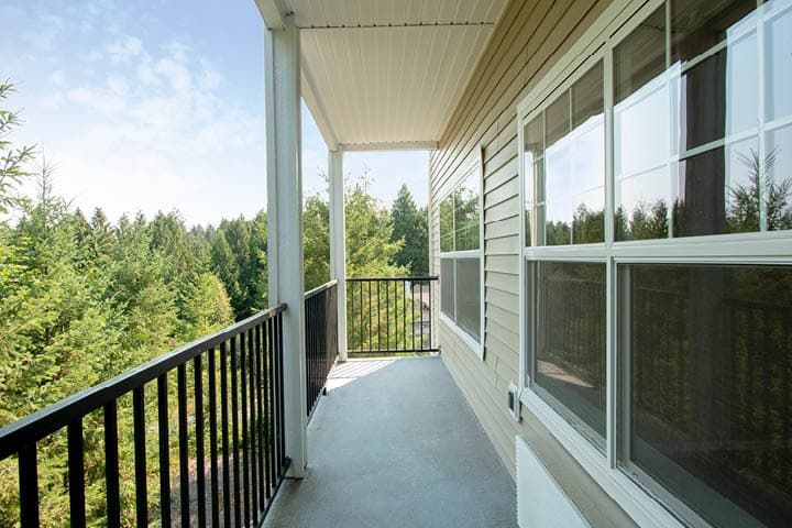 A serene balcony with a view of lush green trees.
