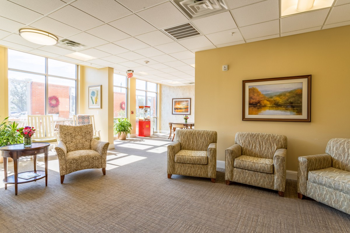 A well-lit waiting room with comfortable chairs and artwork on the walls.