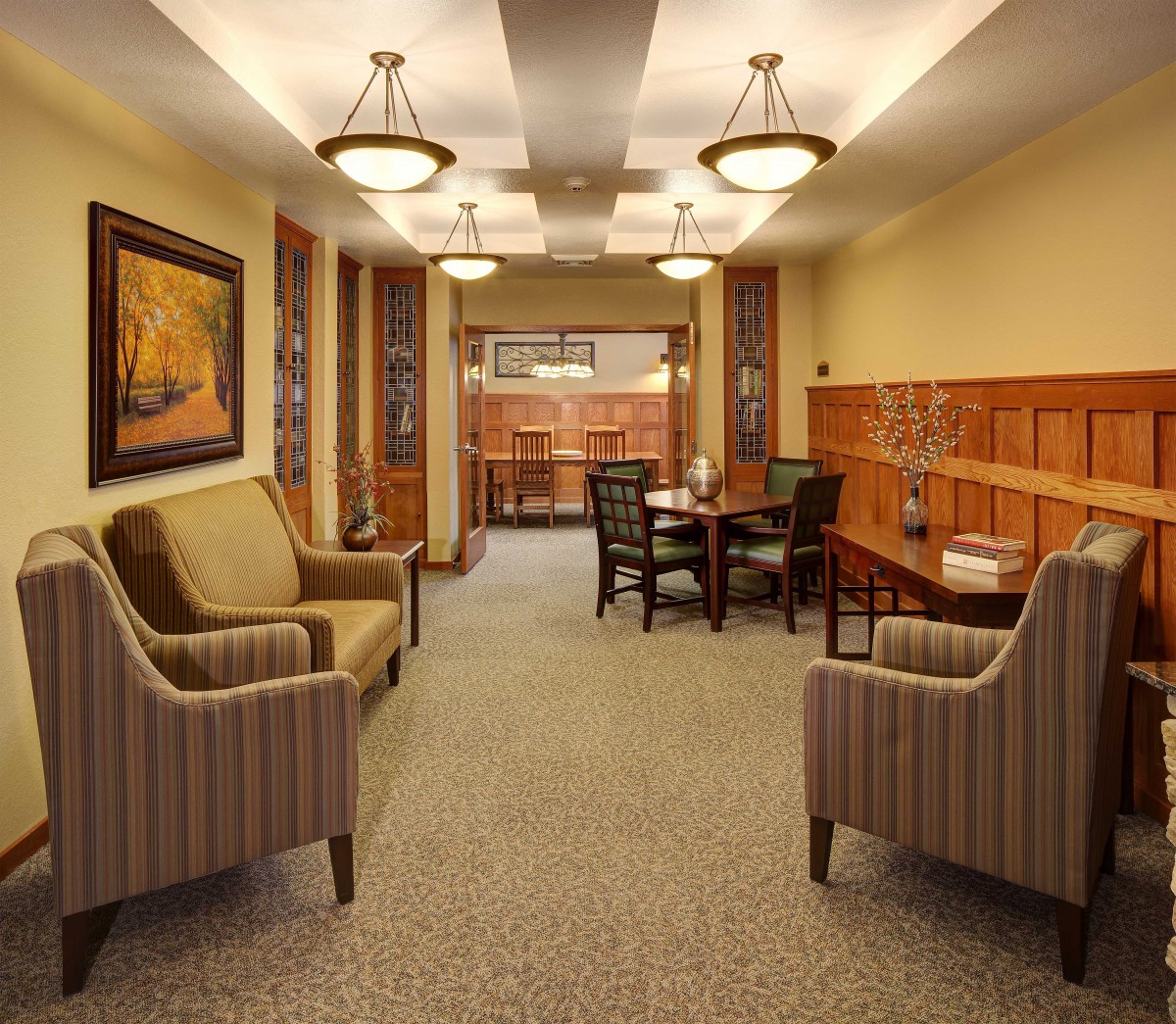 A cozy lounge area featuring armchairs, a table, and decorative lighting.