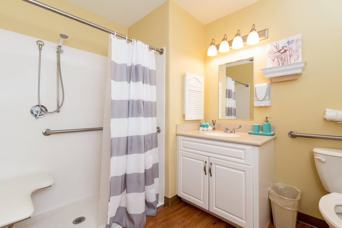 A cozy bathroom with a striped shower curtain and a well-lit vanity.