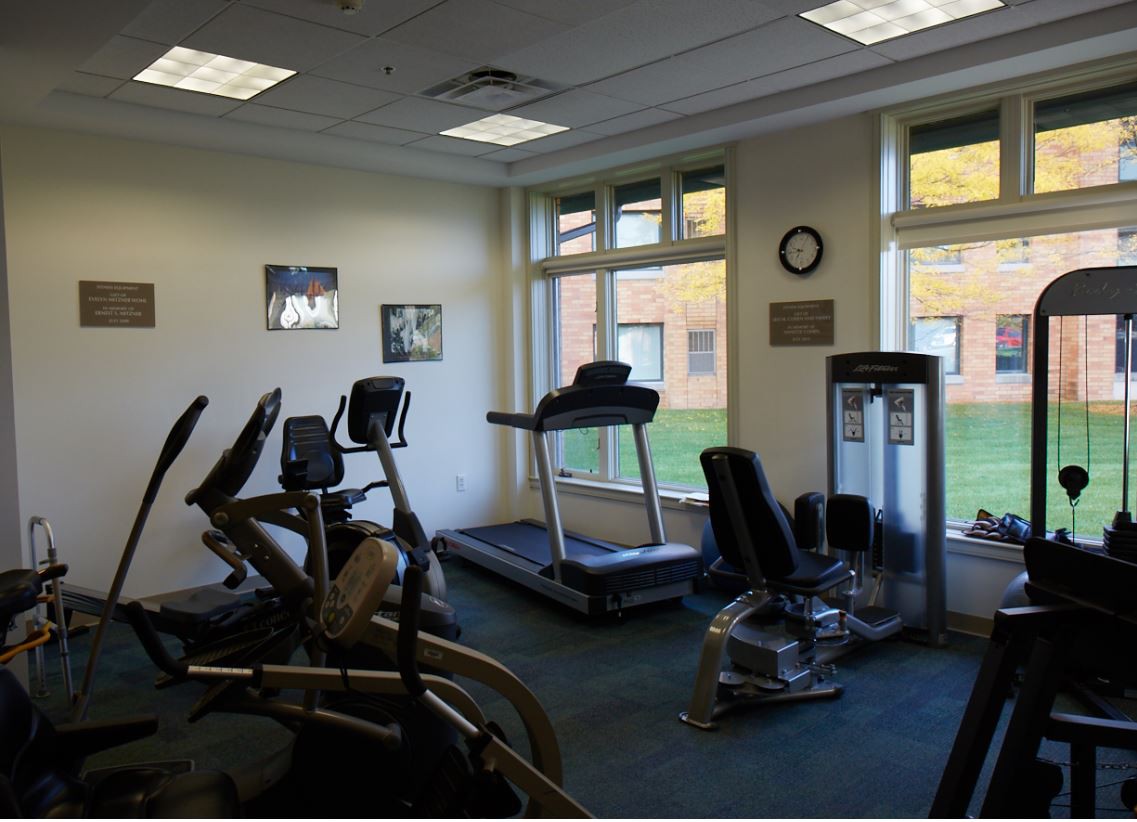 A small gym with cardio fitness equipment including treadmills and exercise bikes.