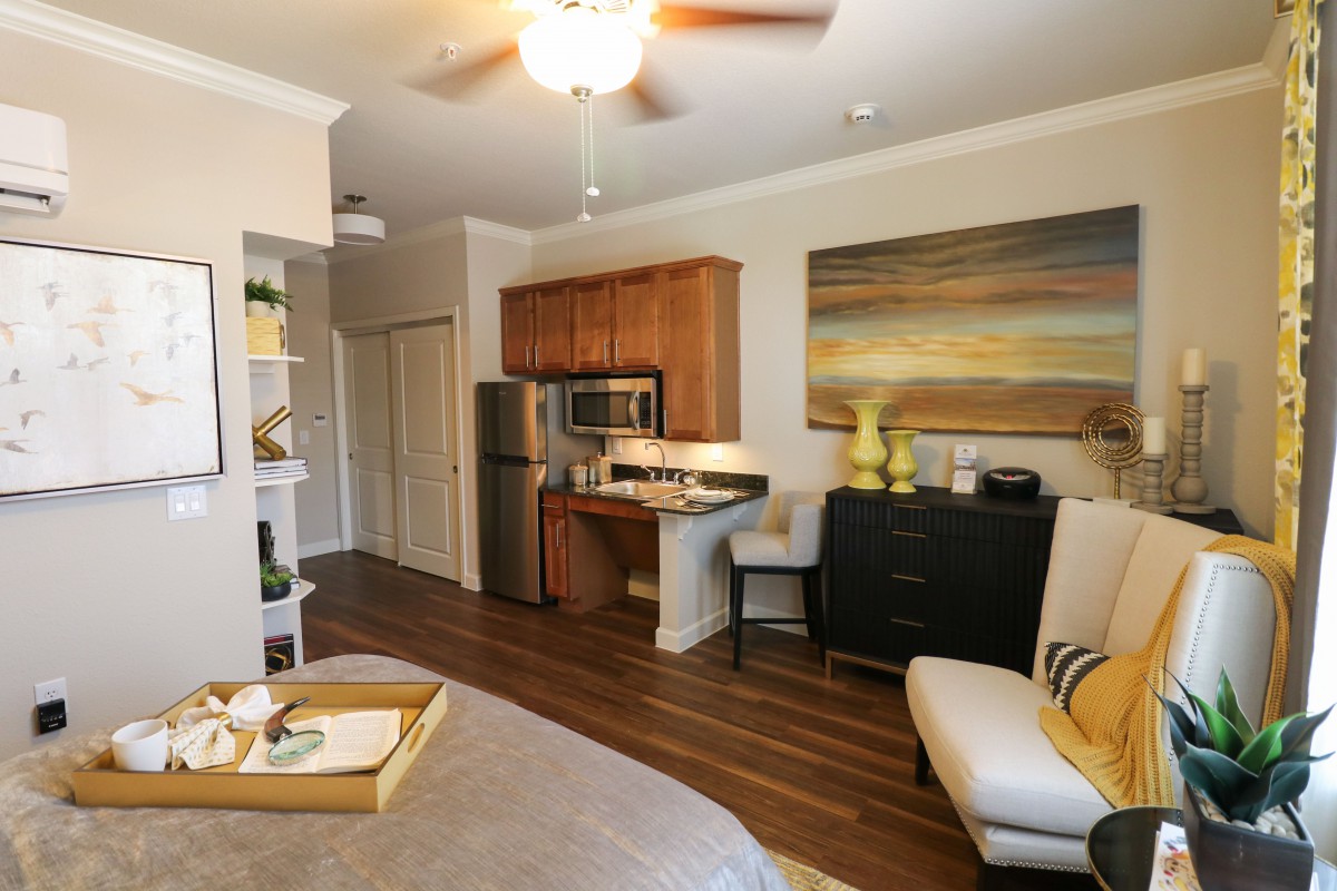 A cozy and modern studio apartment with a kitchenette and stylish decor.