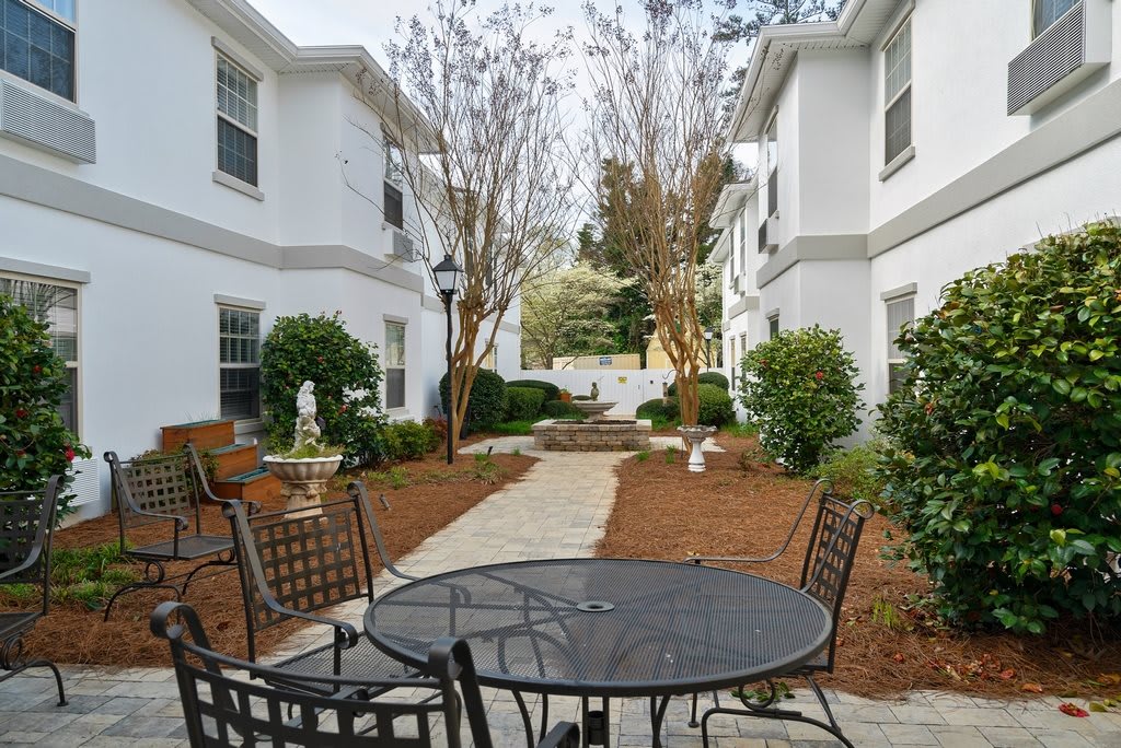 A well-maintained courtyard with outdoor seating between apartment buildings.