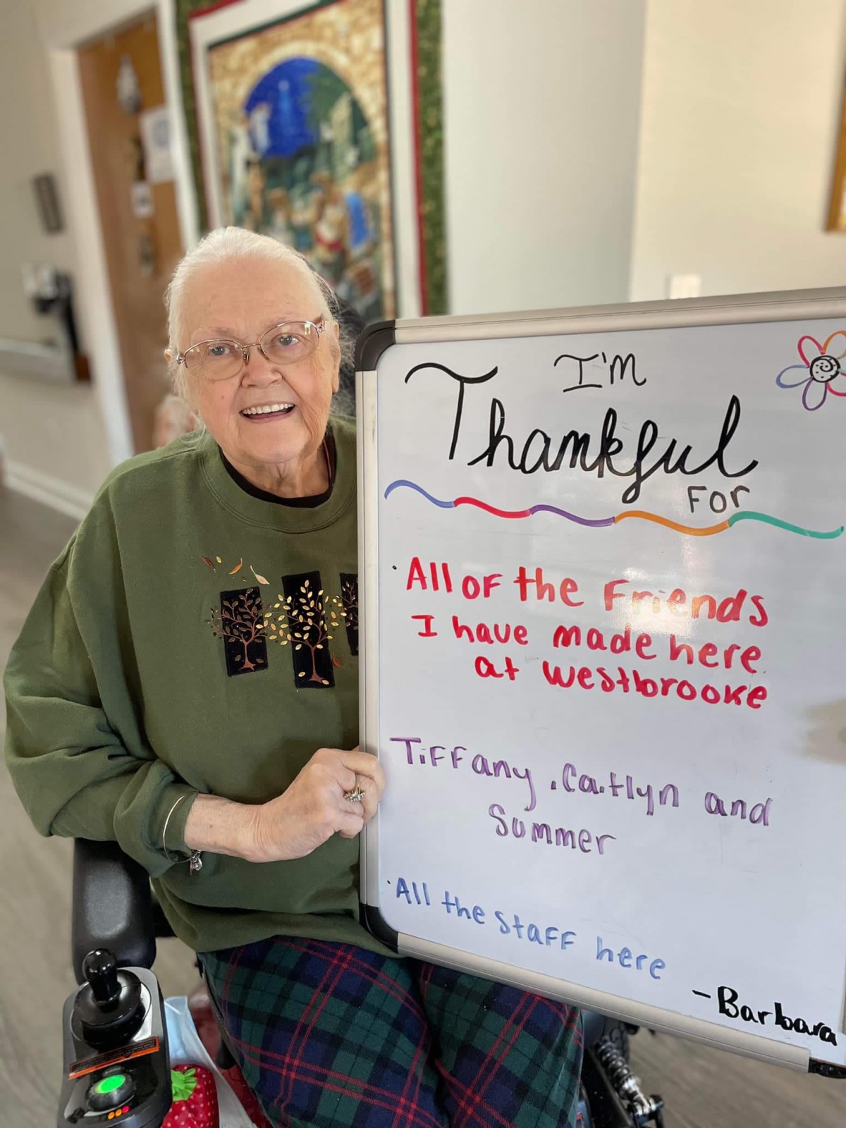 An elderly person expresses gratitude for friends and staff at Westbrooke on a whiteboard.