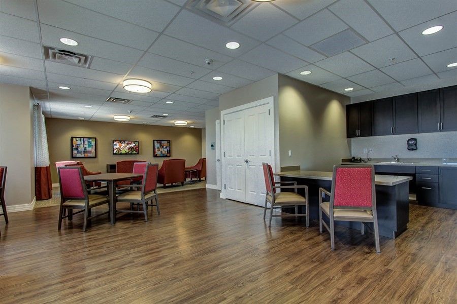 A spacious restaurant dining area with wooden floors and neatly arranged tables and chairs.