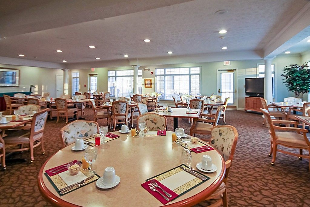 A spacious dining area with neatly arranged tables and chairs, well-lit and ready for guests.