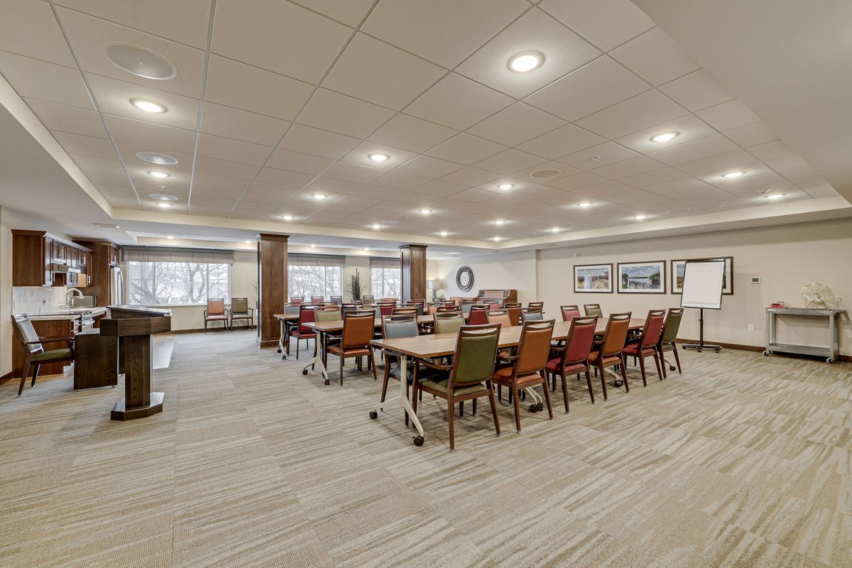 A spacious conference room set up with tables and chairs, ready for a meeting.