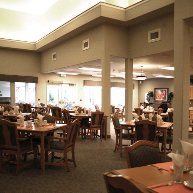 A spacious and well-lit dining area with neatly arranged tables and chairs.