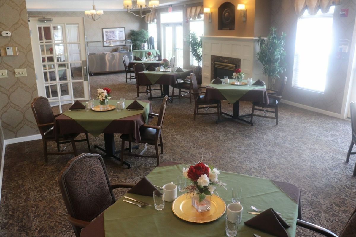 Elegant dining room with neatly set tables and floral centerpieces.
