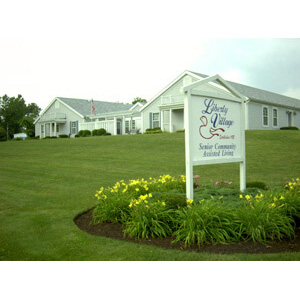 A welcoming entrance to a community facility, surrounded by well-maintained grass and flowers.
