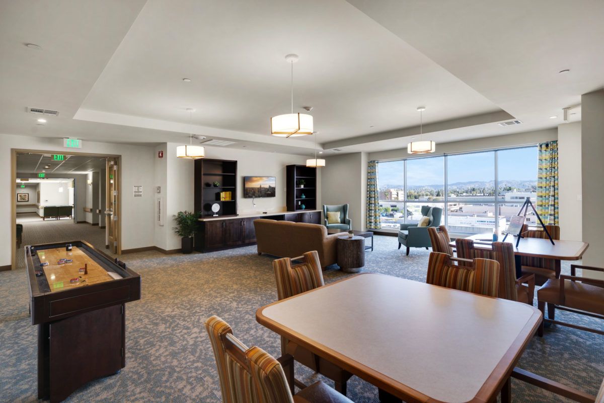 A spacious and modern lounge area featuring comfortable seating and a panoramic window view.