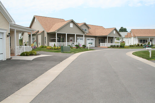 A charming suburban house with a well-maintained landscape and a curved driveway.