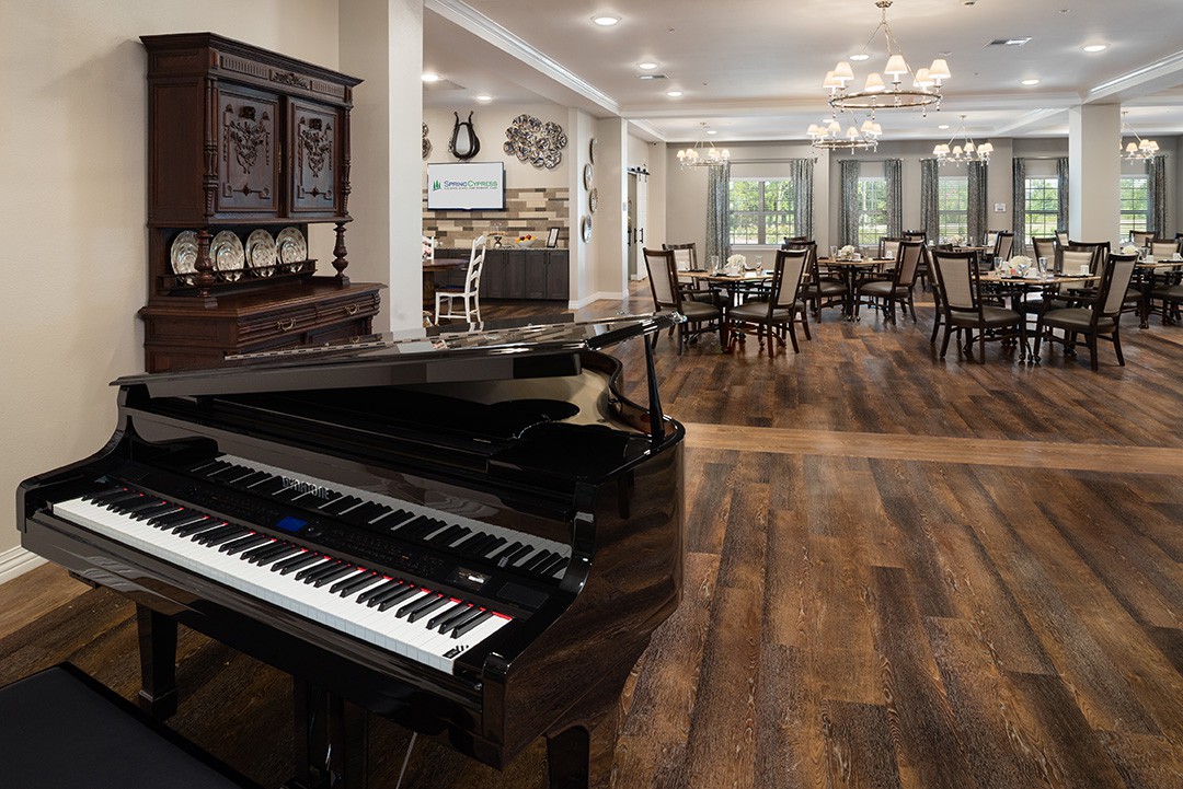 An elegant dining room with a grand piano and wooden flooring.