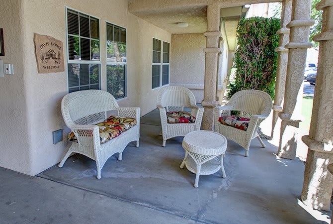 A cozy outdoor patio area with wicker chairs and a small table.