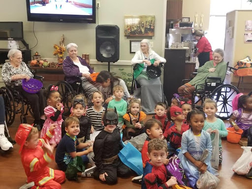 A joyful gathering of children in costumes celebrating Halloween with their elderly friends.